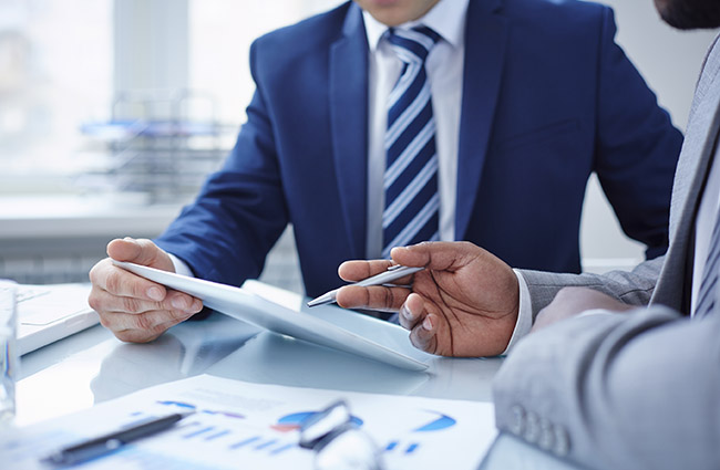 Image of two businessmen discussing computer project