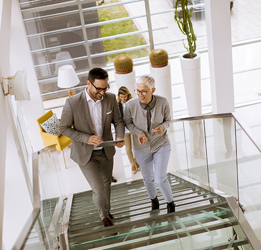 Group of businessmen and businesswomen walking and taking stairs in an office building